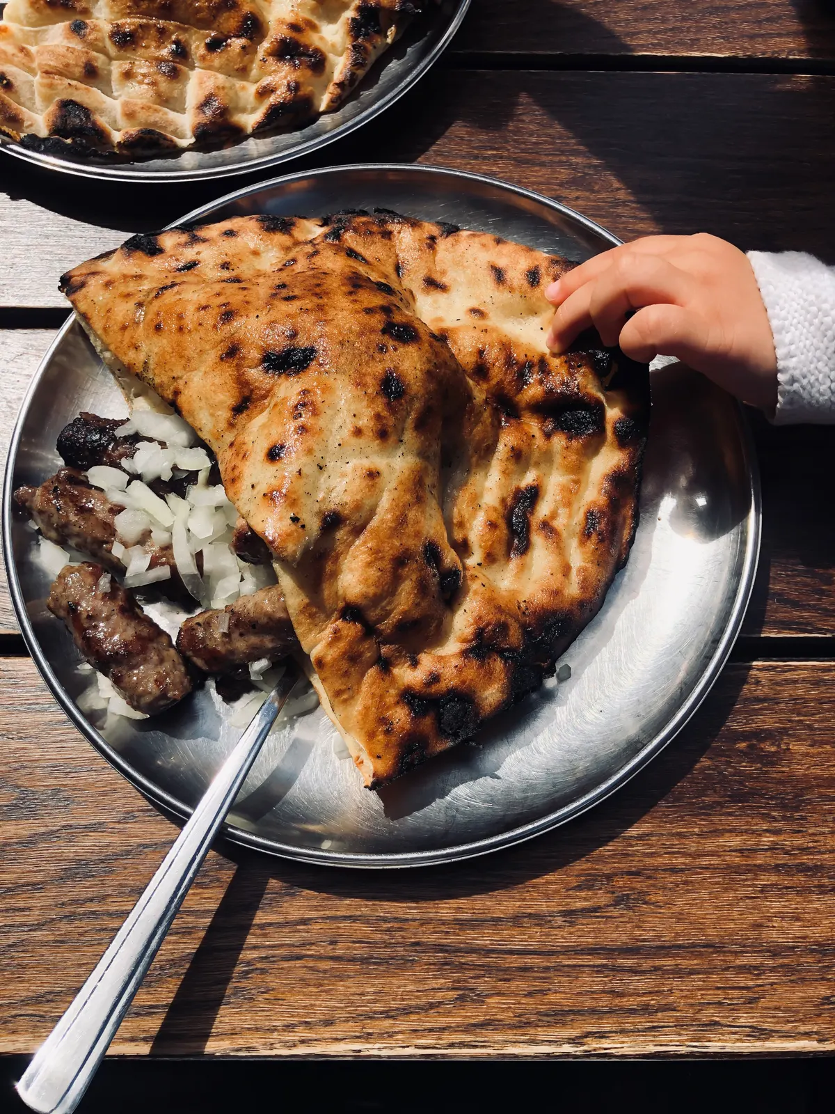 Bosnian cevapi in somun bread with raw onion