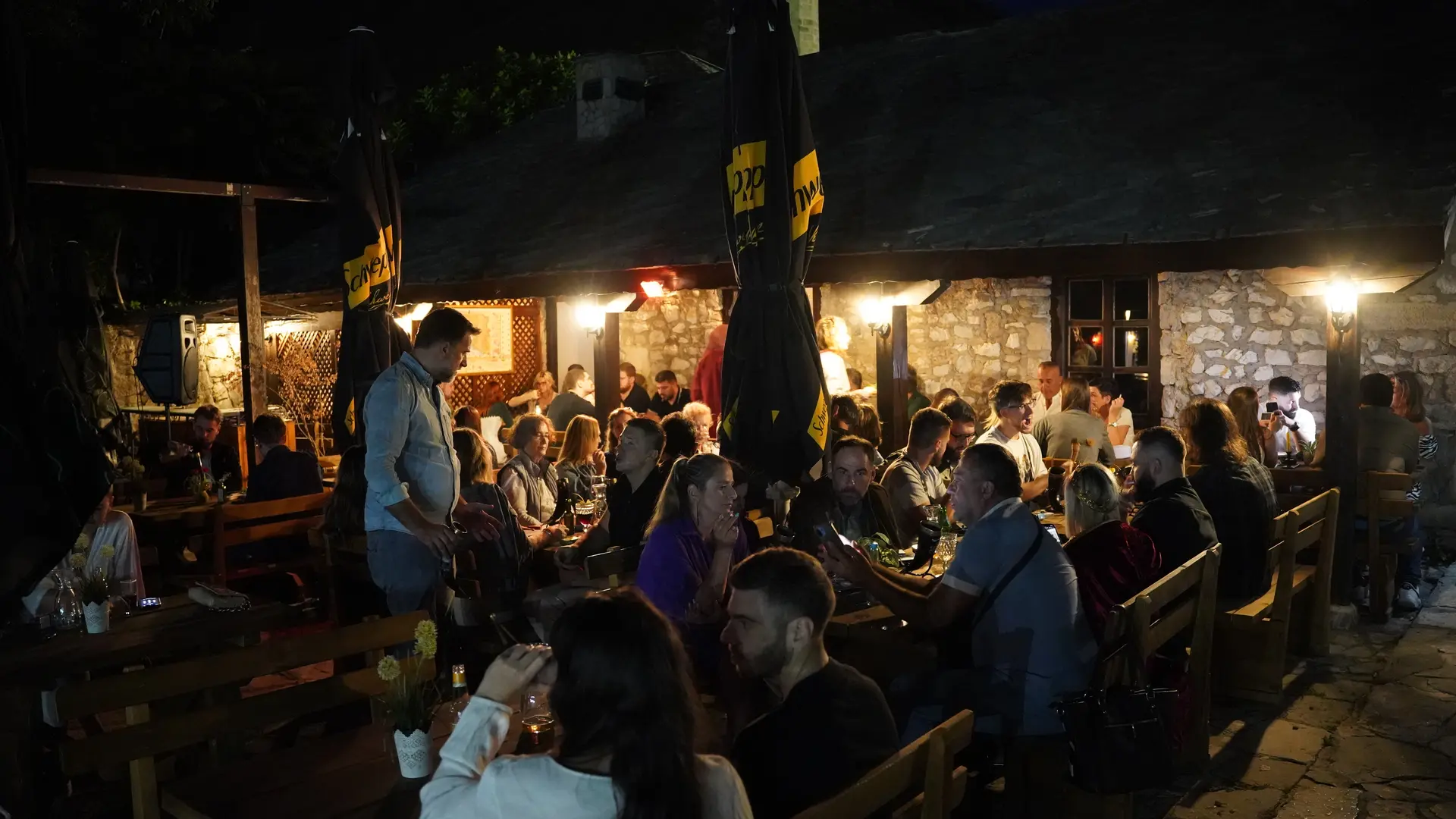 Guests dining inside Timber & Stone Tavern beneath chandeliers and medieval decor